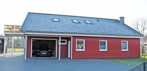 a red garage with a truck inside of it at Trenter Fewo mit Sonnenterrasse in Trent