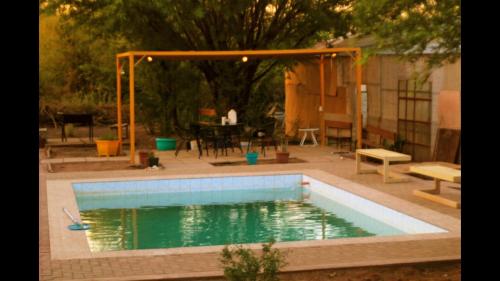 a swimming pool in a backyard with a table and a patio at Cabañas rústico in San Pedro de Atacama