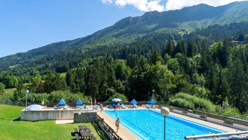 a swimming pool with a mountain in the background at Appartement Velaer Valmorel in Valmorel