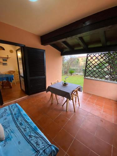 a living room with a table and a patio at Bilocale al Villaggio degli ulivi SAN TEODORO in San Teodoro