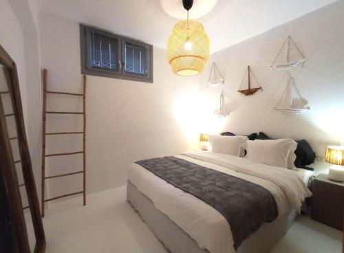 a bedroom with a bed and a ladder and a lamp at The Nine Graces - Kastraki Villas with Private Swimming Pool in Kastraki Naxou