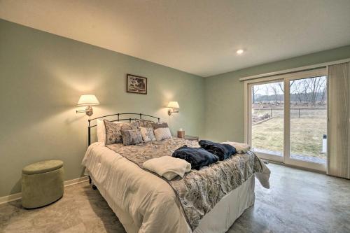 um quarto com uma cama e uma grande janela em Family Home on Crystal Lake with Private Beach! em Hart