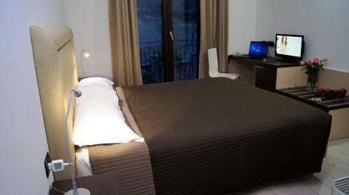 a bedroom with a bed and a desk with a computer at Hotel e trattoria San Giorgio in Piossasco