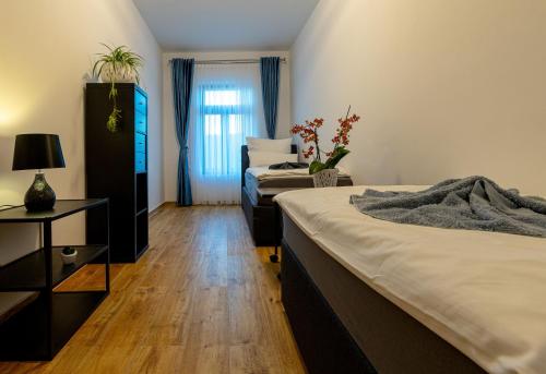 een slaapkamer met 2 bedden en een tafel met een lamp bij 368 Plagwitz Apartment Kulturviertel in Leipzig