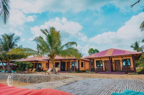 een huis aan het strand met een palmboom bij Mecaja Beach House in Roxas