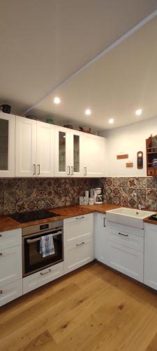 a kitchen with white cabinets and wooden floors at Ferienwohnung Hager Kuchl in Kuchl