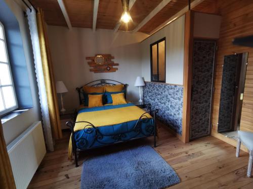 una camera da letto con un letto con cuscini gialli e blu di DOMAINE DES 3 CYPRÈS Chambre MIMOSA Chez Nath & Pat a Fumel
