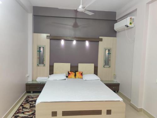 Cette chambre comprend un grand lit et un ventilateur de plafond. dans l'établissement Om Paradise, à Ujjain