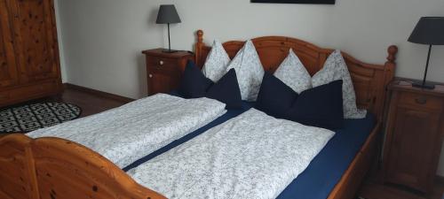 a bed with blue and white sheets and pillows at Ferienwohnung Hager Kuchl in Kuchl