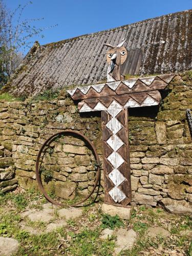 an old stone building with a cross and a wooden door at FORET TOTEM - Hébergements nature et bien-être en pleine forêt in Persquen