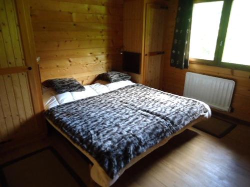 サン・ジャン・ド・シックスにあるChalet Saint-Jean-de-Sixt, 5 pièces, 12 personnes - FR-1-459-7の木造キャビン内のベッド1台が備わるベッドルーム1室を利用します。