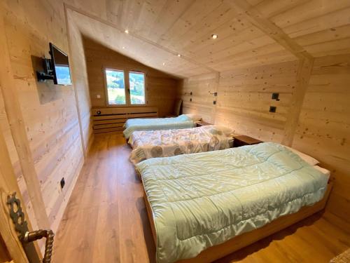 - 3 lits dans une chambre dotée de murs en bois dans l'établissement Appartement Rénové 8 Pers Centre Village La Clusaz, Balcon Sud, Proche Commerces et Pistes - FR-1-459-15, à La Clusaz