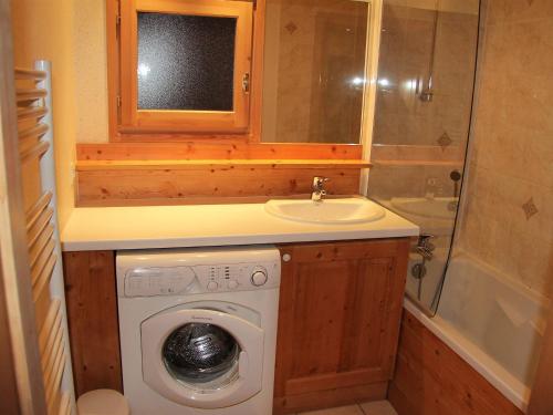 une petite salle de bains avec un lave-linge et un lavabo dans l'établissement Appartement 3 chambres pour 6-8 personnes avec balcon et garage à La Clusaz - FR-1-459-10, à La Clusaz