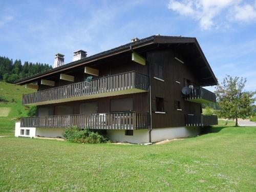 un grand bâtiment avec des balcons sur le côté dans l'établissement Duplex à La Clusaz avec cheminée et balcon, 2 ch, parking - FR-1-459-12, à La Clusaz