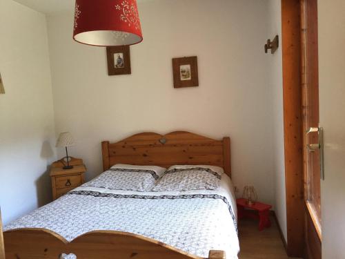 une chambre avec un lit et une lampe rouge dans l'établissement Confortable 3 pièces, départ ski, parking, WiFi, La Clusaz - FR-1-459-38, à La Clusaz