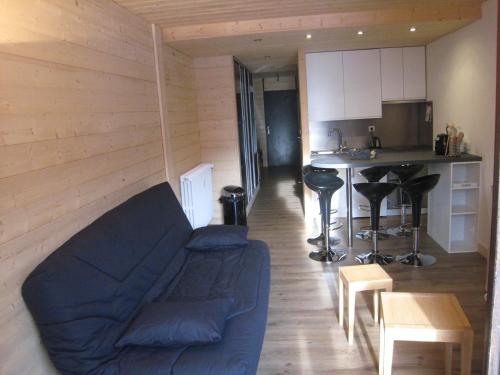 un salon avec un canapé bleu et une cuisine dans l'établissement Appartement 2 Pièces, Ski au Pied, Balcon Sud, Confort pour 6 - FR-1-459-62, à La Clusaz