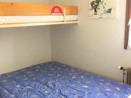 - une chambre avec des lits superposés et un couvre-lit bleu dans l'établissement 2 pièces proche pistes avec balcon - FR-1-459-63, à La Clusaz