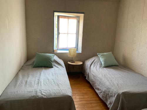 two twin beds in a room with a window at Chambres, Table d'Hôtes et Gites Les Mesanges in Saint-Jean-de-Sauves