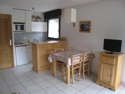 une cuisine avec une table et des chaises ainsi qu'une télévision dans l'établissement Appartement 4 Pers, Centre Village, Terrasse Sud - La Clusaz, Proche Commerces et Pistes - FR-1-459-85, à La Clusaz