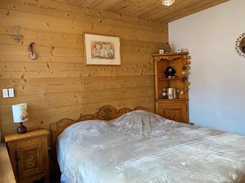 une chambre avec un lit et un mur en bois dans l'établissement Appartement Rénové 3 Pièces au Centre de La Clusaz avec Balcon et Garage - FR-1-459-40, à La Clusaz