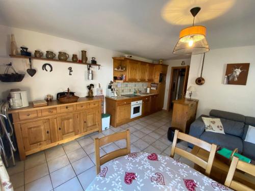 Il dispose d'une cuisine et d'un salon avec un canapé et une table. dans l'établissement Charmant Appartement 3 Pièces aux Pieds des Pistes - La Clusaz - FR-1-459-90, à La Clusaz
