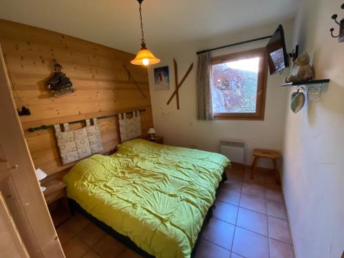 une chambre avec un lit vert et une fenêtre dans l'établissement Charmant Appartement 3 Pièces aux Pieds des Pistes - La Clusaz - FR-1-459-90, à La Clusaz