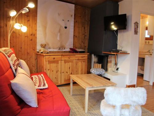 un salon avec un canapé rouge et une table dans l'établissement Appartement T2 Centre Village avec Balcon & Cheminée, Proche Piscine et Pistes - FR-1-459-72, à La Clusaz