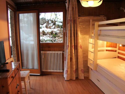 une chambre avec un lit superposé et une fenêtre dans l'établissement Appartement T2 Centre Village avec Balcon & Cheminée, Proche Piscine et Pistes - FR-1-459-72, à La Clusaz