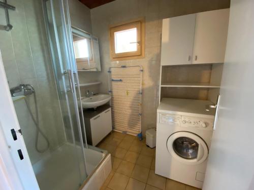 une petite salle de bains avec un lave-linge et un lavabo dans l'établissement 2 Pièces au Centre avec Cuisine Equipée et Balcon – La Clusaz - FR-1-459-116, à La Clusaz
