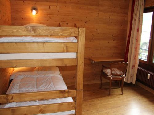 - une chambre avec 2 lits superposés dans une cabane en rondins dans l'établissement Appartement 2 Pièces Rénové avec Balcon et Garage au Cœur de La Clusaz - FR-1-459-74, à La Clusaz
