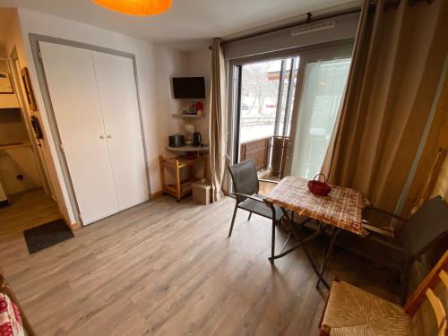 un salon avec une table et une fenêtre dans l'établissement Studio cosy rénové au centre de La Clusaz, balcon, parking privé, proche commerces et pistes - FR-1-459-84, à La Clusaz