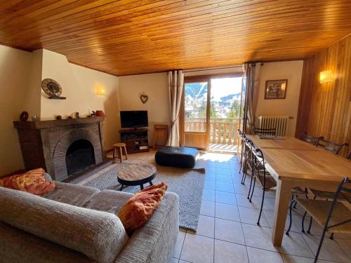 un salon avec un canapé et une table dans l'établissement Appartement de 3 pièces avec balcon, cheminée et Wifi à La Clusaz - FR-1-459-99, à La Clusaz
