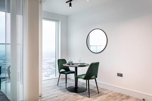 a dining room with a table and chairs and a mirror at Icon Tower Flat VII in London