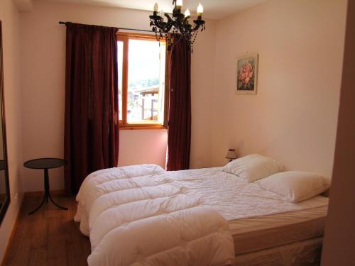 une chambre avec un grand lit et une fenêtre dans l'établissement Charmant appartement au centre du village, proche des stations de ski - 4 personnes - FR-1-459-163, à Saint-Jean-de-Sixt