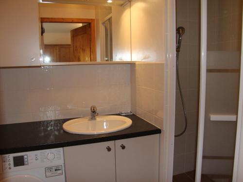 une salle de bain avec un lavabo et un miroir dans l'établissement Charmant appartement au centre du village, proche des stations de ski - 4 personnes - FR-1-459-163, à Saint-Jean-de-Sixt