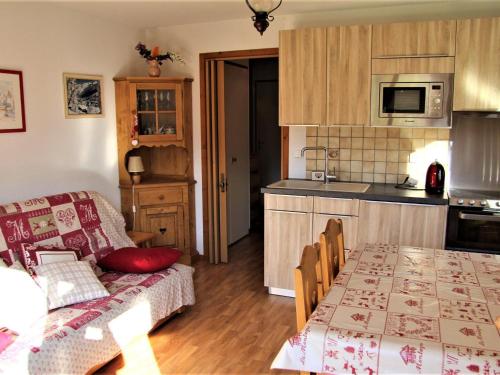 Il dispose d'une cuisine et d'un salon avec une table et un canapé. dans l'établissement Appartement cosy avec balcon, parking individuel et WiFi à Saint-Jean-de-Sixt - FR-1-459-165, à Saint-Jean-de-Sixt