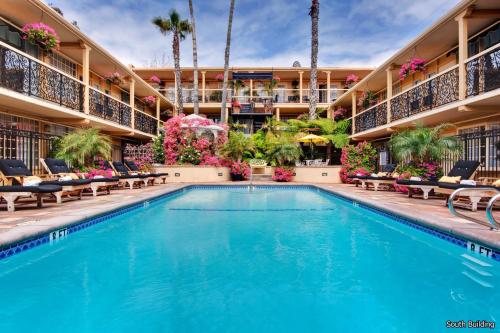 a swimming pool at a hotel with chairs and flowers at 14 West Laguna Beach in Laguna Beach