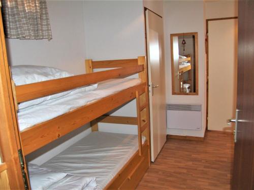 - une chambre avec 2 lits superposés et une porte dans l'établissement Appartement cosy avec balcon, parking individuel et WiFi à Saint-Jean-de-Sixt - FR-1-459-165, à Saint-Jean-de-Sixt