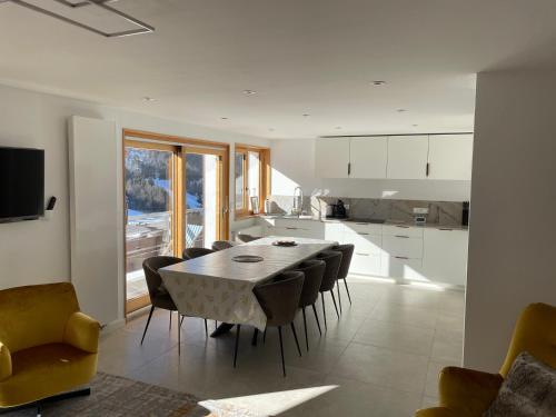 une cuisine et une salle à manger avec une table et des chaises dans l'établissement Duplex rénové 2020, 4 chambres, balcon, parking à La Clusaz - FR-1-459-171, à La Clusaz