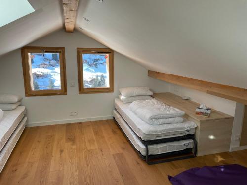 Cette chambre mansardée comprend 2 lits et 2 fenêtres. dans l'établissement Duplex rénové 2020, 4 chambres, balcon, parking à La Clusaz - FR-1-459-171, à La Clusaz