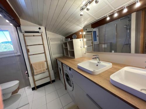 une salle de bain avec un lavabo, des toilettes et un miroir dans l'établissement Appartement Mansardé 3 Pièces 74m², Balcon Sud, Parking Privé, Wifi - FR-1-459-183, à La Clusaz