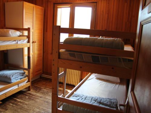 une chambre avec trois lits superposés dans une cabine dans l'établissement Chalet familial 5 chambres pour 8 personnes à Saint-Jean-de-Sixt - FR-1-459-160, à Saint-Jean-de-Sixt