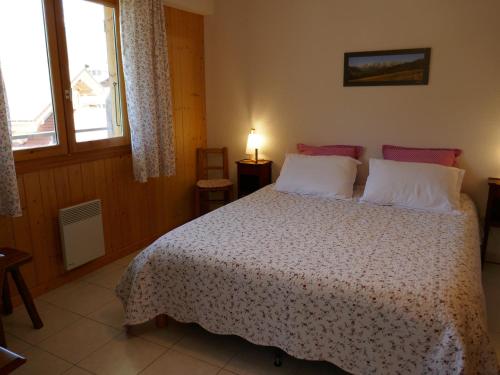 une chambre avec un lit et deux fenêtres dans l'établissement Appartement cosy 3 pièces avec balcon et garage, à proximité des pistes et commerces - FR-1-459-164, au Grand-Bornand