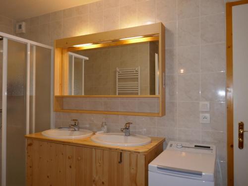 une salle de bain avec deux lavabos et un miroir dans l'établissement Appartement cosy 3 pièces avec balcon et garage, à proximité des pistes et commerces - FR-1-459-164, au Grand-Bornand
