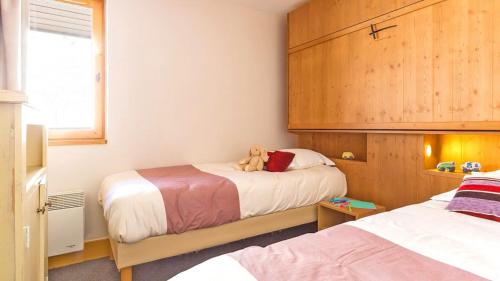 ein Schlafzimmer mit 2 Betten und einem Teddybär auf dem Bett in der Unterkunft Appartement Belle Plagne in Belle Plagne