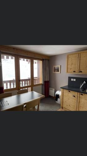 uma cozinha com uma mesa e uma secretária e algumas janelas em Appartement Belle Plagne em Belle Plagne