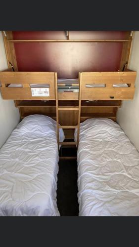2 Betten befinden sich in einem kleinen Zimmer. in der Unterkunft Appartement Belle Plagne in Belle Plagne