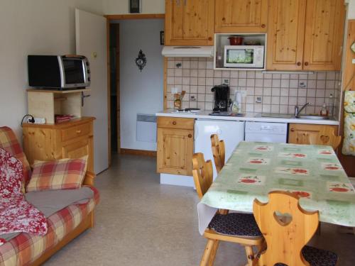 une cuisine avec une table, une table et un canapé dans l'établissement Appartement pour 4-6 personnes au cœur du village, Saint-Jean-de-Sixt (BLA003) - FR-1-459-162, à Saint-Jean-de-Sixt