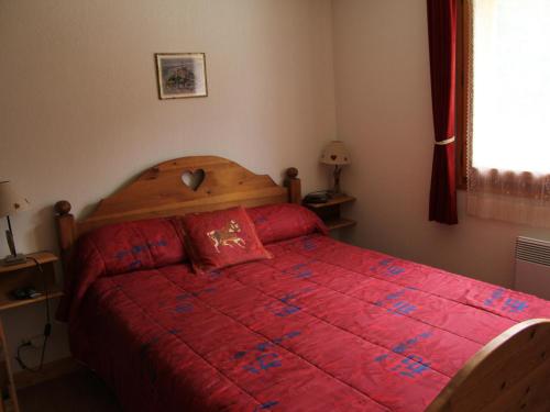 - une chambre avec un lit rouge et une couette rouge dans l'établissement Appartement pour 4-6 personnes au cœur du village, Saint-Jean-de-Sixt (BLA003) - FR-1-459-162, à Saint-Jean-de-Sixt