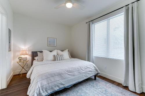 a white bedroom with a bed and a window at All-New, Waterfront Condo in Downtown Sarasota! in Sarasota